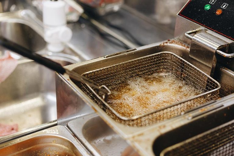 deep fryer with used cooking oil making food in restaurant and commercial kitchen