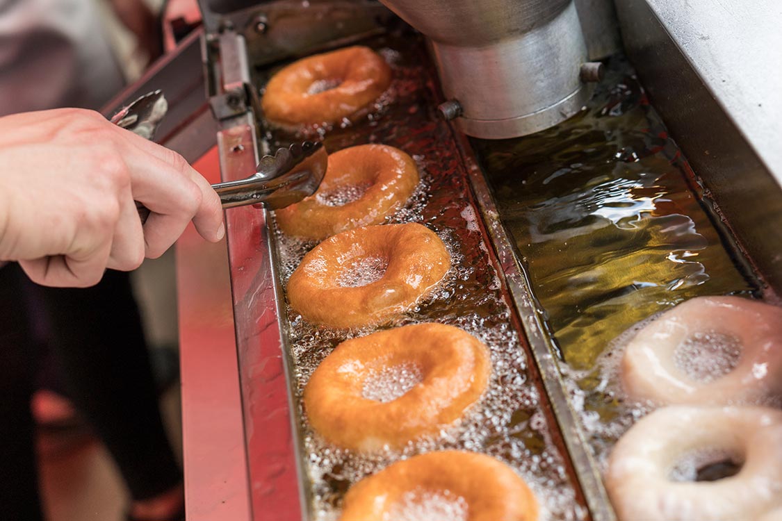 Preparation of fried donuts in a hot oil.