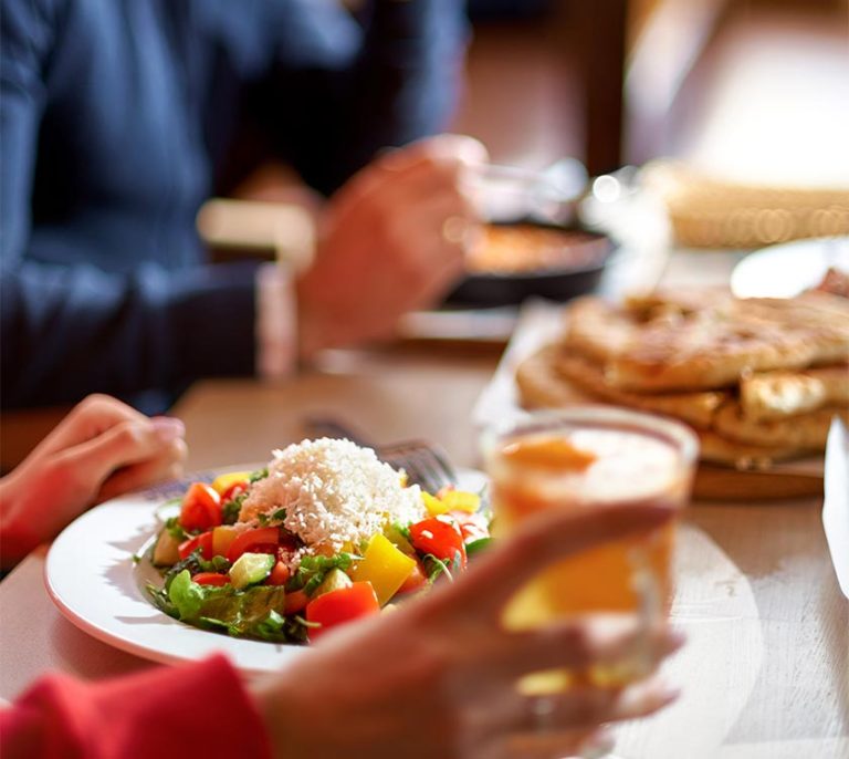 Hands view of young people eating brunch in trendy bar restaurant - Healthy lifestyle, food trends concept - Focus on left woman hand, dish