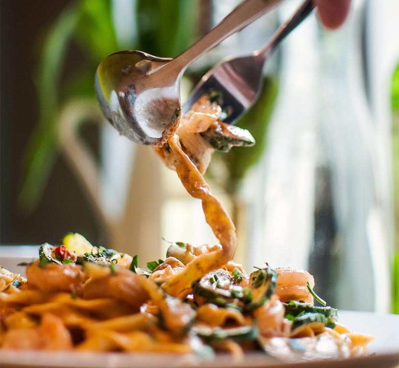 Vertical shot of delicious pasta with fried onions in a white plate