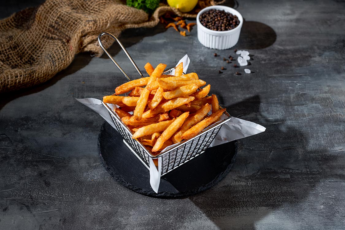 Traditional fast food potato chips fries in deep fryer